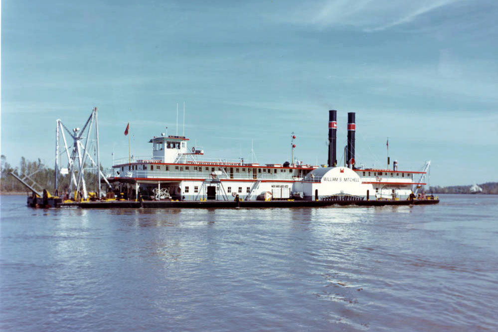 Side view of a large white dredge in a large body of water Side view of a large white dredge in a large body of water